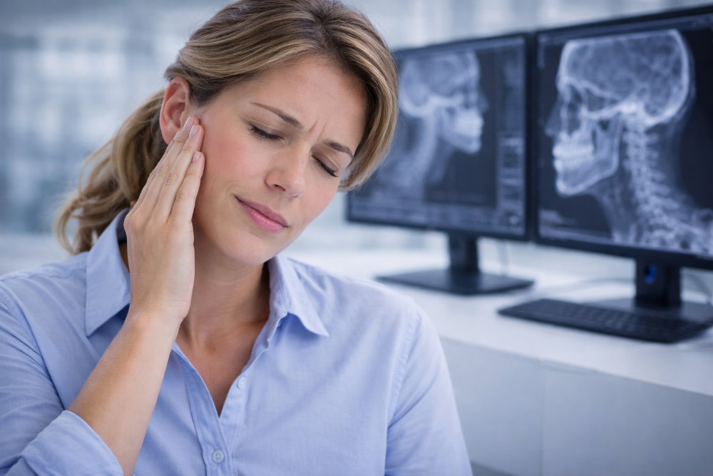 Жена държи челюстта си при дискомфорт, свързан с темпоромандибуларната става